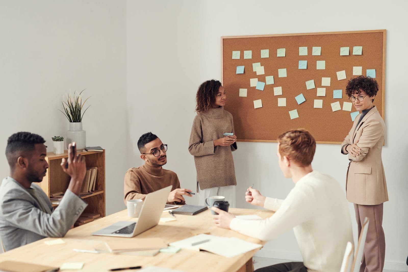 Agenturteam bespricht ein Projekt vor einer Pinnwand